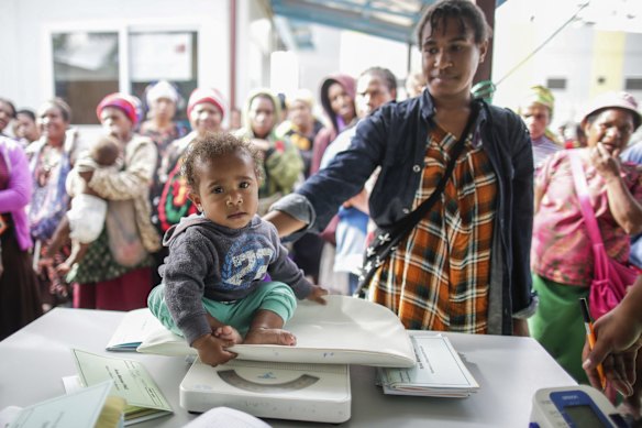 Ernatha Nik with her 11-month-old daugher Kate Nik who is getting weighed at the Susu Mamas clinic in Mount Hagen. 
