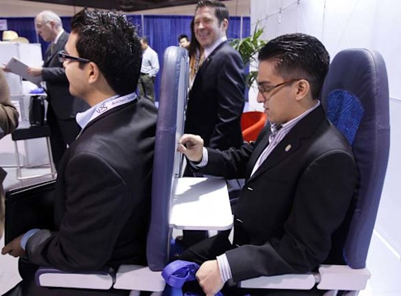 Ddier Resendiz tries out Italian company Aviointeriors' new aircraft 'standing seat' which has 23 inches of legroom, instead of the current economy class average of 30 inches, at the Aircraft Interiors Expo in Long Beach.