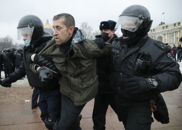 Police detain a man during a protest against the jailing of opposition leader Alexei Navalny.