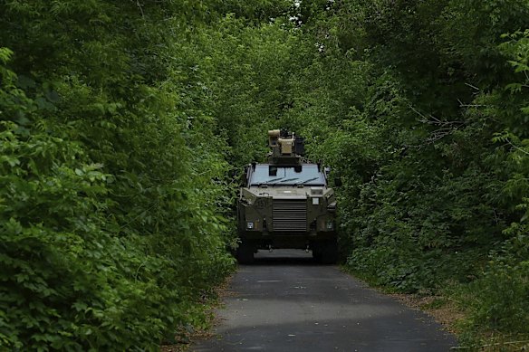 An Australian Bushmaster vehicle being used by a mechanised infantry unit drives along a road in a secret position in the Donbas, heading towards the frontlines in Ukraine.