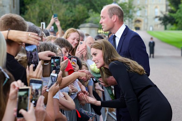 Catherine, Princess of Wales, and Prince William, Prince of Wales, speak with members of the public on the long walk at Windsor Castle.