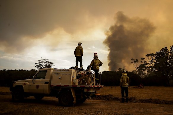 Fire crews work to defend Bombay resident Les Hart's property as the North Black Range bushfire approaches, seen near Bombay, NSW.