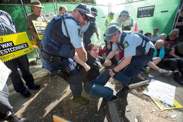 Police remove a protester from the site on Euston Road.