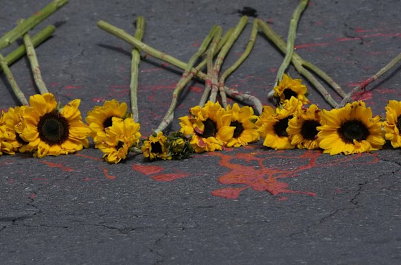 Sunflowers alongside red paint to symbolize blood shed, lay in front of the Russian Embassy in Quito, Ecuador, during a protest against Russia's invasion of Ukraine.