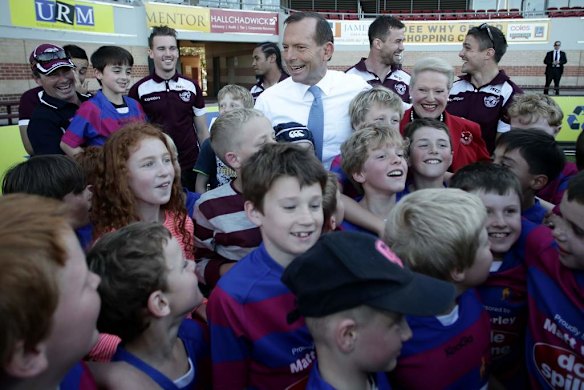 Opposition Leader Tony Abbott and Liberal MP Bronwyn Bishop pose for photos with the Under-9 Manly Christian Brothers players during their visit to Brookvale Oval in NSW.