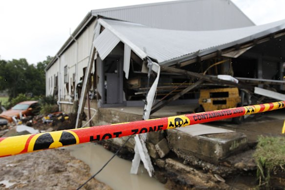 Contamination tape due to asbestos at the tyre shop, next to the site where a house was washed away on Dungog Road.