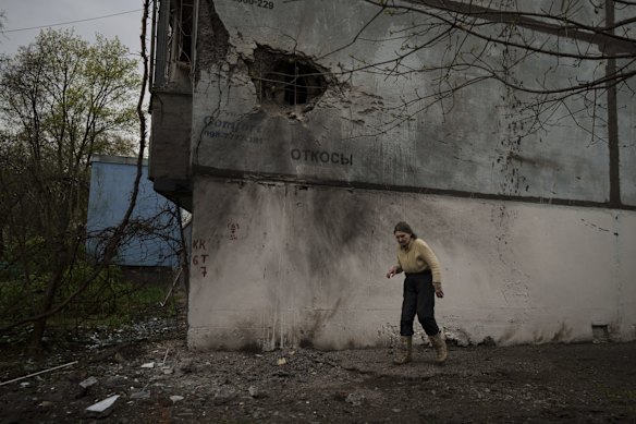 A woman passes a damaged building after a Russian bombardment in Kharkiv. 