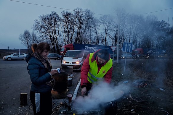 A volunteer serves hot tea to people fleeing the conflict in Ukraine, hoping to cross the Polish border. 