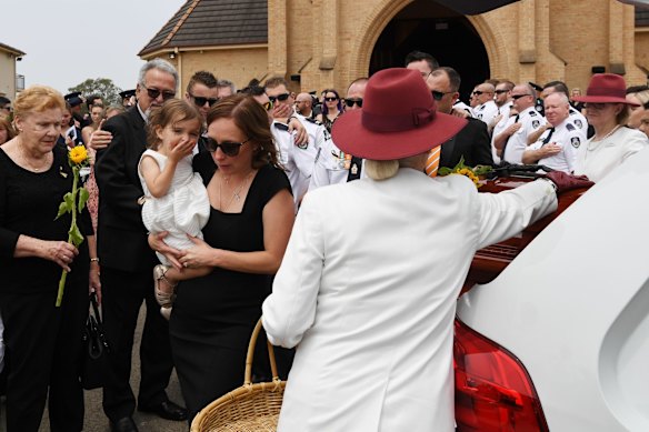Melissa and Charlotte O'Dwyer, the wife and young daughter of Rural Fire Service volunteer Andrew O'Dwyer, farewell their husband and father during the funeral for NSW RFS volunteer Andrew ODwyer.