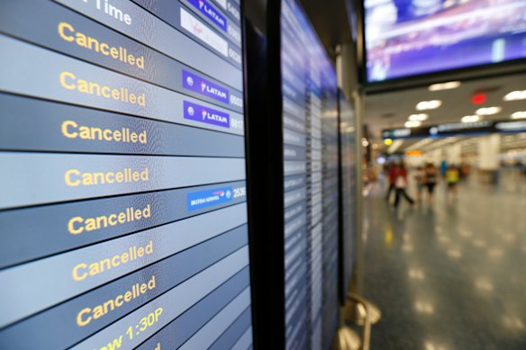 A monitor listing cancelled flights at Miami International Airport.
