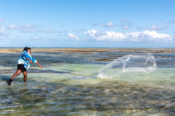 Collecting clam and spider shell with the Mabo family at Las Beach. Annie Zaro throws the casting net over a school of mullet.