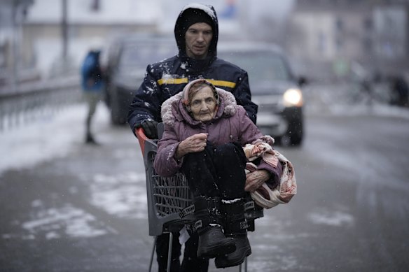 An elderly woman is carried in a shopping cart after being evacuated from Irpin, on the outskirts of Kyiv, Ukraine.