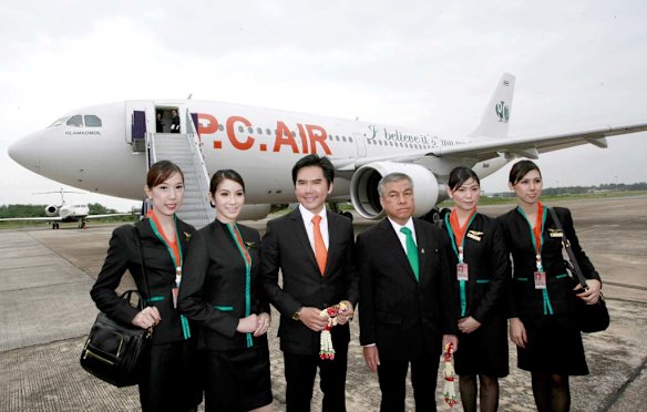 Thai transsexual flight attendants Chayathisa Nakmai, left, Dissanai Chitpraphachin, 2nd left, Nathatai Sukkaset, 2nd right, and Phuntakarn Sringern, right, pose for photograph with PC Air President Peter Chan, 3rd left, and Chairman of PC Air Chawiwat Glamkomol, 3rd right.