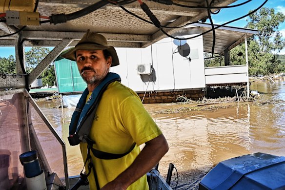 Wayne Smith searching for missing caravans which were washed downstream and dumped at St George Caravan Park. His family own and run the Dargle Water ski resort which still inundated after the Hawkesbury River flooded through on Sunday.