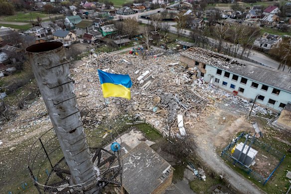 A Ukrainian flag flies over the ruins of Barvinok school in Makariv.