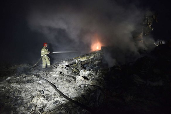 A firefighter sprays water to extinguish a fire in the wreckage of the malaysian airliner.