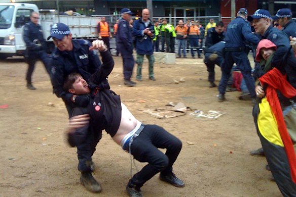 A protester is forcibly removed from the square.