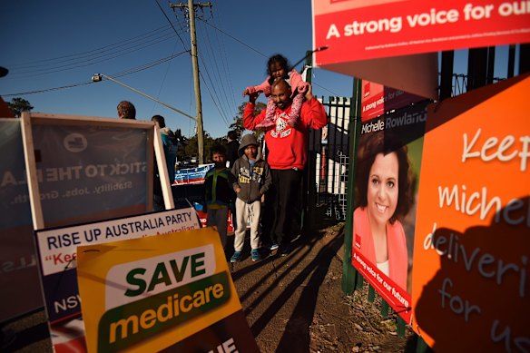 Swas Sachindran 36 (right) carrying his daughter Isabella 3 on his shoulders with sons Issac 4(left) and Immanuel 6 (2nd from left) after casting his vote at the Blacktown South Public School, Blacktown, Sydney. 