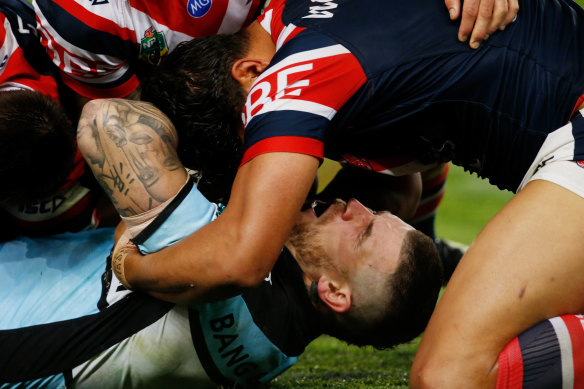 Josh Dugan hurts his neck in a tackle during Saturday's game between the Roosters and the Sharks.