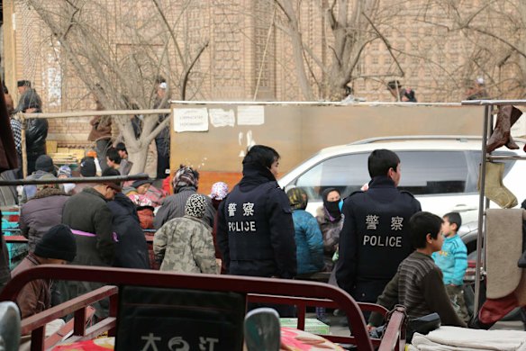 Police wait outside Hotan Mosque during Friday prayers.