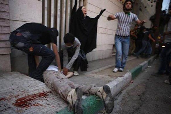 People assist an injured man in Tehran.