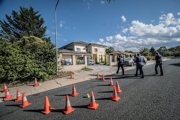 Police officers and forensic staff attend the scene of an overnight shooting and arson attack in Harrington circuit, Kambah. Numerous bullets have hit the home and three vehicles have been set alight. 