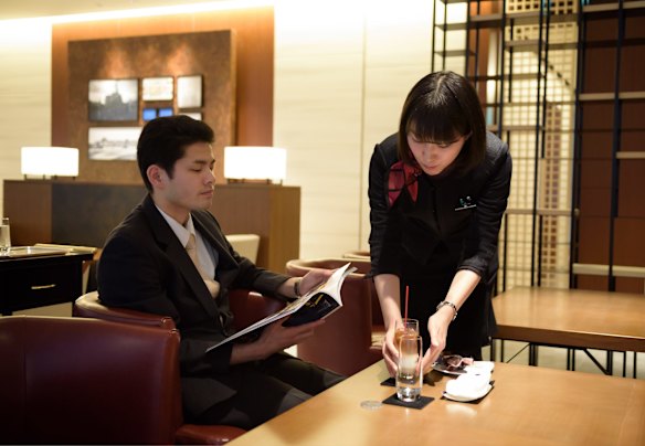 An employee serves a drink to a customer in the View Gold Lounge, operated by East Japan Railway Company and View Card, at Tokyo station in Tokyo, Japan. Passengers on the GranClass can check into this lounge at Tokyo Station before boarding.