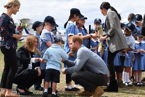 Prince Harry has his beard tickled by school student Luke Vincent.