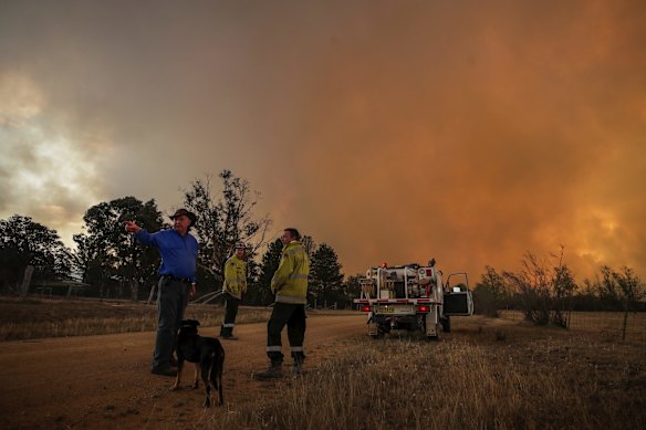 Bombay resident Les Hart watches the North Black Range bushfire approach, seen near Bombay, NSW.