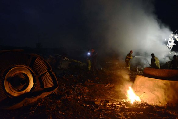 Firefighters extinguish a fire among the wreckages of the malaysian airliner.
