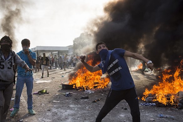  A protesting refugee throws projectiles at Hungarian police at the Horgos border crossing in Serbia. 
