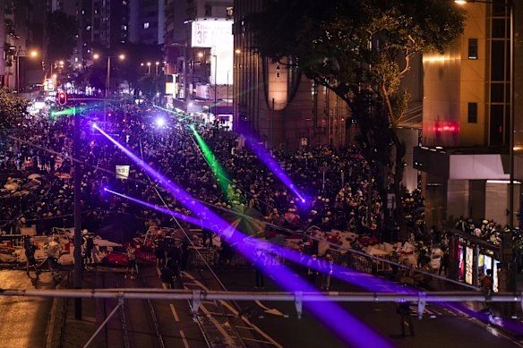 Demonstrators shine laser lights at riot police on Hennessy Road during a protest in the Wan Chai district.