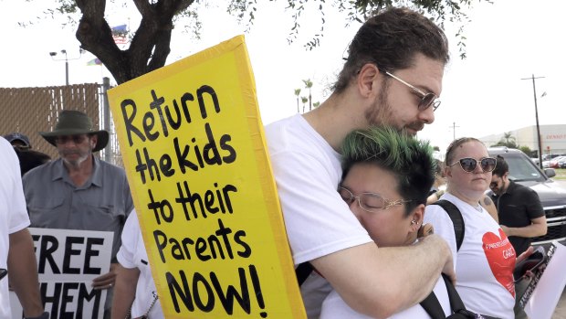 Diana Jung Kim, right, and Homer Carroll, both from Houston, hug during a protest outside the US Border Patrol Central Processing Centre in McAllen, Texas.