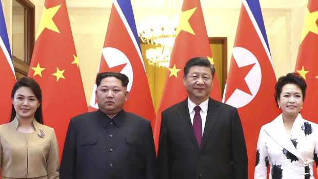 Chinese President Xi Jinping, second from right, and his wife Peng Liyuan, right, and North Korean leader Kim Jong-un, second from left, and his wife Ri Sol-ju, left, pose for a photo at the Great Hall of the People in Beijing. 