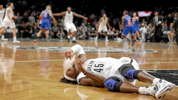 Play goes on ... Brooklyn Nets forward Gerald Wallace lies in pain on the court after a collision in the fourth quarter of the clash against the New York Knicks.