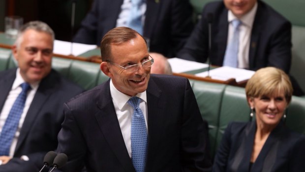 Prime Minister Tony Abbott smiles at the press gallery after he withdraws his description of   Opposition leader Bill Shorten as "the Dr Goebbels of economic policy" during question time  on Thursday.