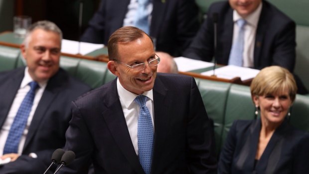 Prime Minister Tony Abbott smiles at the press gallery after he withdraws his description of   Opposition leader Bill Shorten as "the Dr Goebbels of economic policy" during question time  on Thursday.