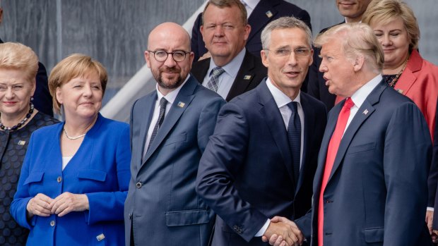 Jens Stoltenberg, secretary general of the NATO, second right, shakes hands with US President Donald Trump as Angela Merkel, Germany's chancellor, second left, Charles Michel, Belgium's prime minister, second left, watch.