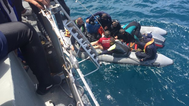 Divers retrieve a body during a search operation.