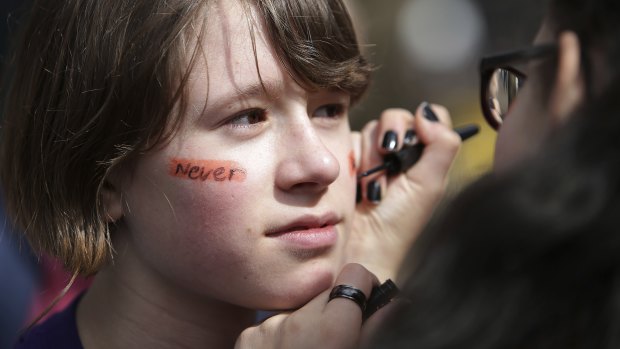 Student gets "Never Again" written on his face as young people gather in Seattle. 