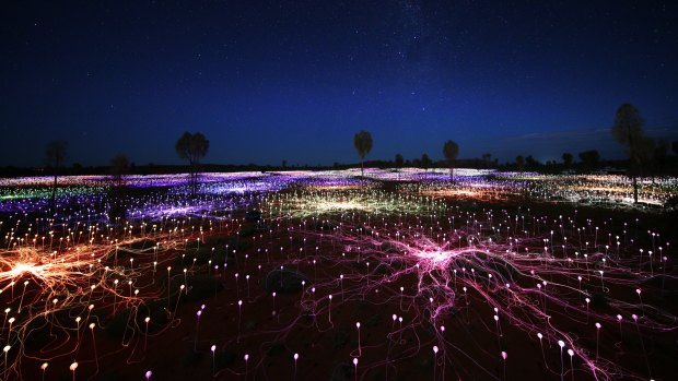 Coloured light carpets the desert around Uluru. 