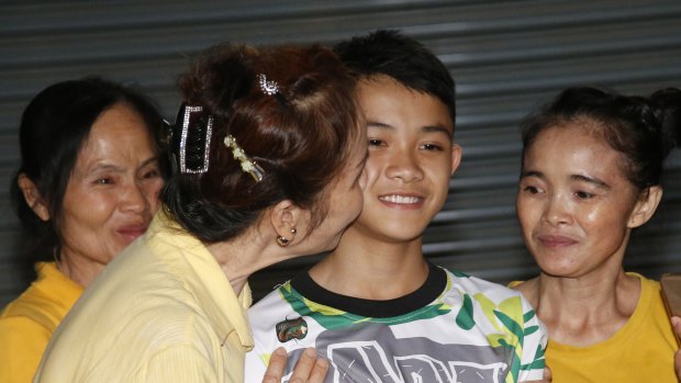 Relatives of Duangpetch "Dom" Promthep, one of the boys rescued from the flooded cave in northern Thailand, greet him as he arrives home on Wednesday.