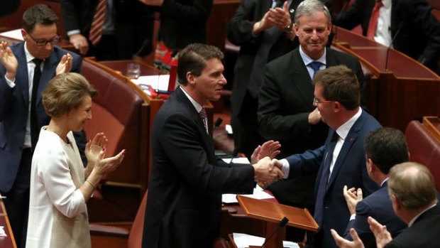 Senator James McGrath is congratulated by Senator Cory Bernardi after delivering his first speech. Photo: Alex Ellinghausen