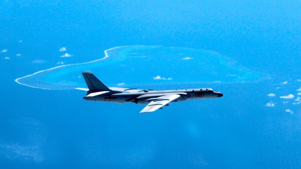 In this undated photo released by Xinhua News Agency, a Chinese H-6K bomber patrols the islands and reefs in the South China Sea. 