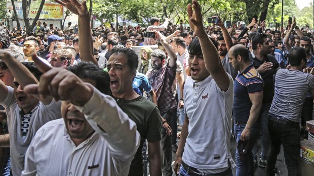 A group of protesters chant slogans at the old grand bazaar in Tehran, Iran.