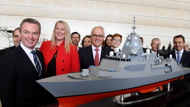 Prime Minister Malcolm Turnbull (centre), Minister for Defence Industry Christopher Pyne (left), BAE head Gabby Costigan (third left) and Navy personnel pose with a model of the new Hunter Class Frigate after the announcement of the contract in Adelaide last week.