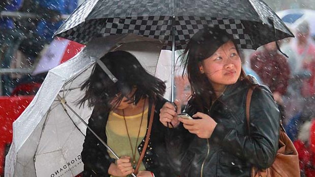Racegoers look for shelter at Albert Park as cooler weather finally arrived in Melbourne.