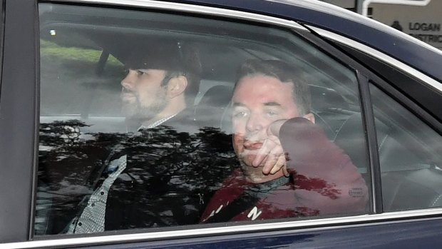 Suspended Logan City mayor Luke Smith (right) leaves Logan Police Headquarters after his arrest.