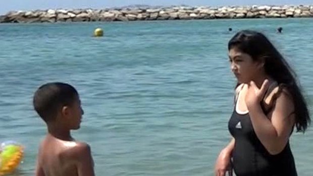 Nissrine Samali, 20, gets into the sea in Marseille, southern France.