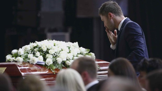 Michael Clarke pauses at his friend Phillip Hughes' casket as he makes his way to the lectern to deliver his tribute.